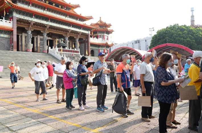 高雄市三民區公所於10月17日在覆鼎金保安宮廣場舉辦敬老活動，民眾排隊領宣導品。圖/高市府提供