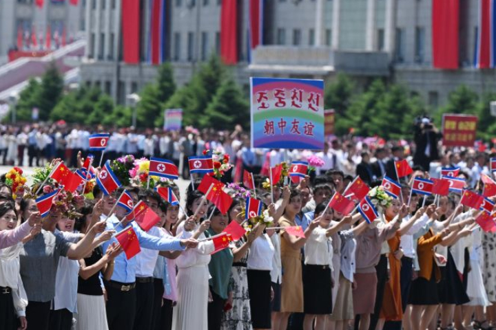 習近平與妻子彭麗媛乘車轉往金日成廣場,途中北韓民眾沿途夾道歡迎。圖/取自新華社