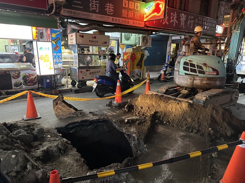 北市府澄清，是因為附近建案的重型車輛反覆碾壓，導致原本鬆軟的土質出現坍塌，並非天坑。圖/中央社