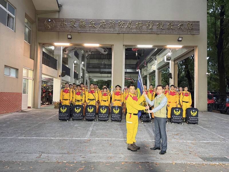 緬甸28日地震後，屏東縣政府消防局出動40人搜救隊伍，各式救災裝備器材共4000公斤，29日清晨到內政部消防署訓練中心集結，由屏東縣副縣長黃國榮（前右）授旗。 圖/ 中央社