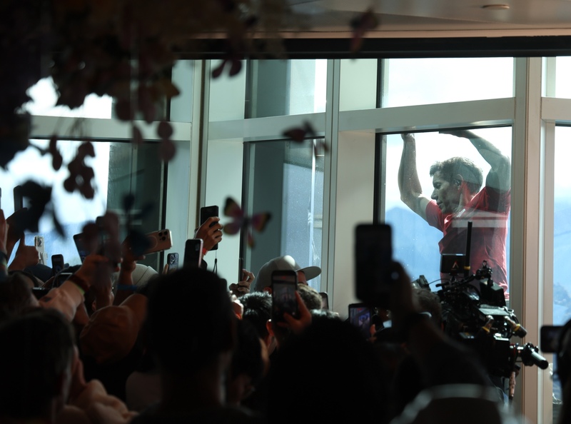 霍諾德挑戰徒手攀爬台北101,許多民眾在89樓觀景台為他加油打氣,拿起手機拍攝紀錄。圖/中央社