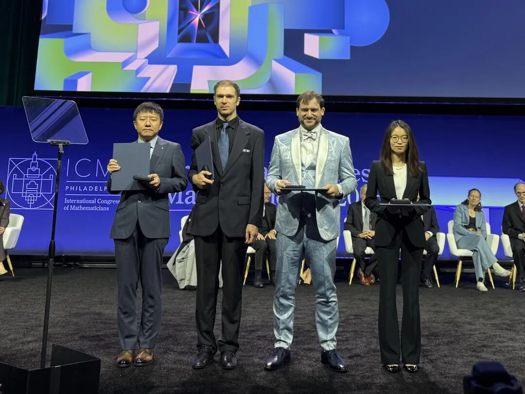 2026年費爾茲獎四位得主於美國費城國際數學家大會頒獎典禮合影。左起為鄧煜、John Pardon、Jacob Tsimerman 與王虹。(圖/新華社)