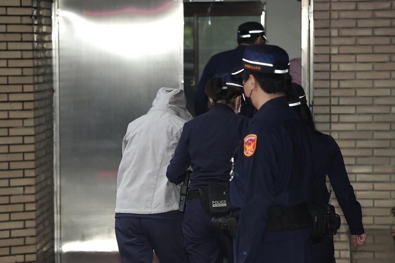 涉嫌虐童的保母劉若琳（灰色外套）在法警戒護下從後門下車，步入法院。圖/中央社