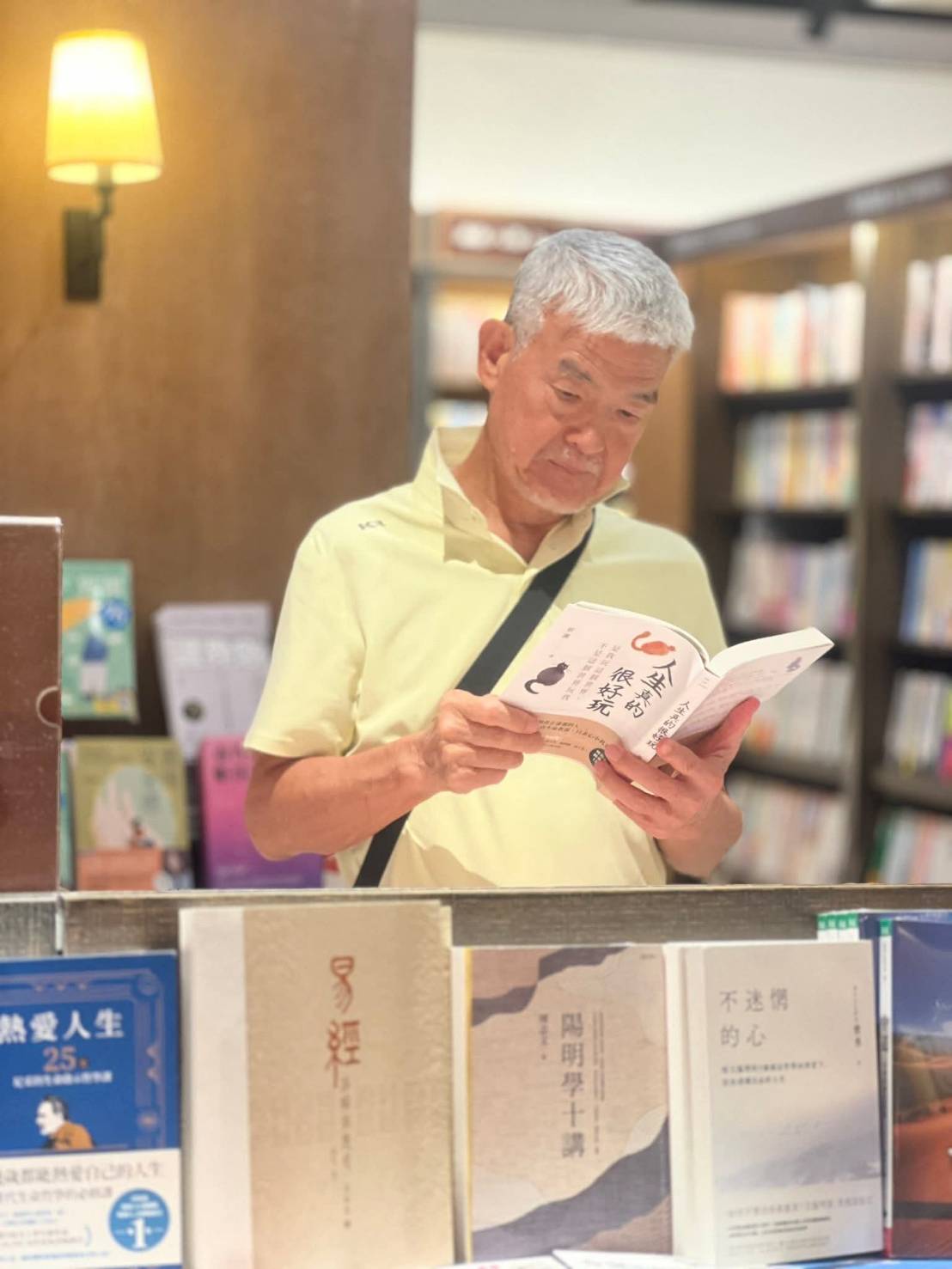 林炳生在書店站著看香港「玩家」蔡瀾寫的《人生真的很好玩》。圖/取自林炳生臉書