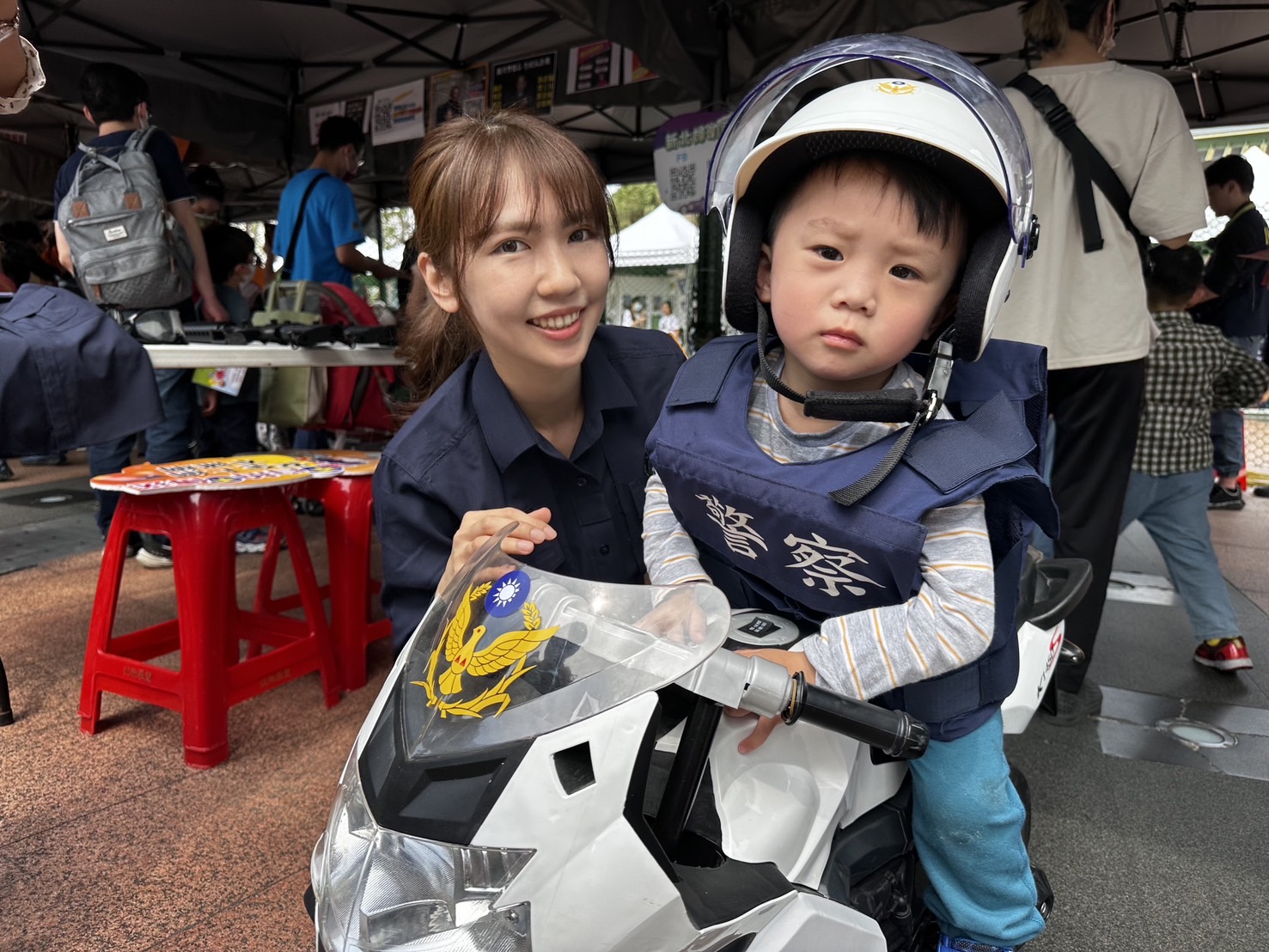 兒童坐上小型警用機車，模擬警察執行勤務。圖/新北市政府警察局提供