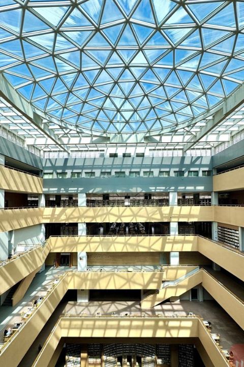 成都大學圖書館內部是「回」字形中庭設計,挑高的空間搭配通透落地窗,自然光從頭頂傾瀉而下,把大廳照得明亮又溫柔。圖/取自《川觀新聞》