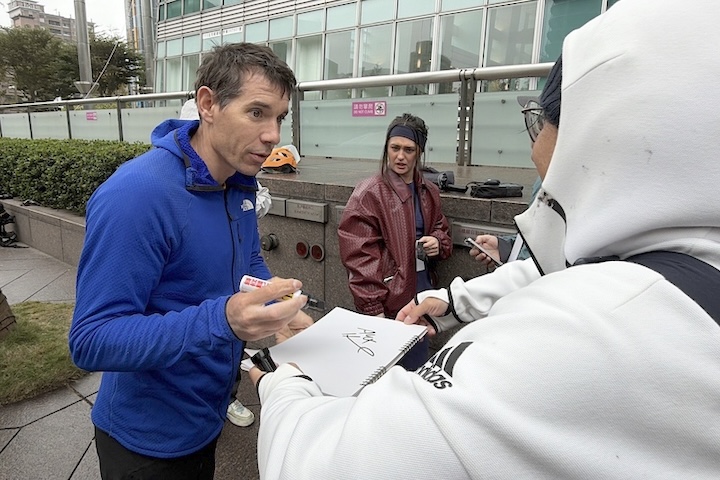 美國自由攀岩好手霍諾德左)將於24日挑戰徒手攀登台北101,他21日幫粉絲簽名。圖/中央社