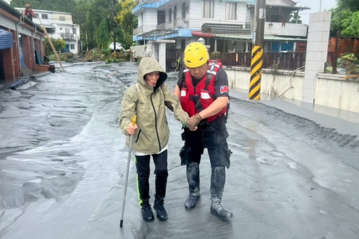新北市消防局也進駐花蓮災區救災，圖為警義消25日協助婦人撤離災區。圖/新北市消防局提供