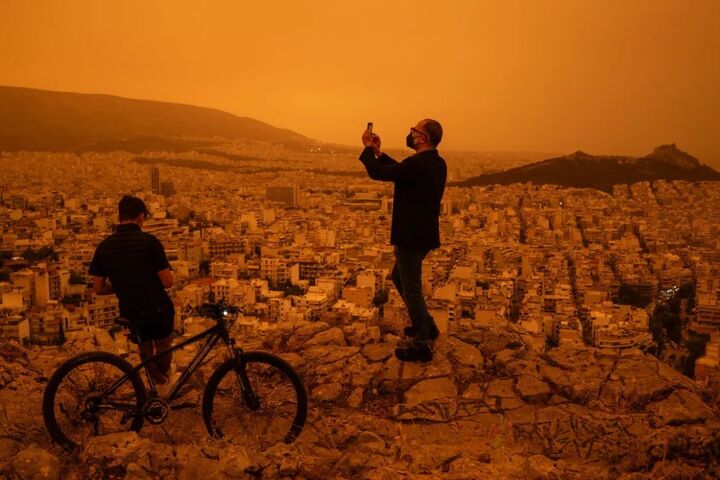 遊客在雅典橙紅色的天空下留影。圖/取自watan6090《推特》