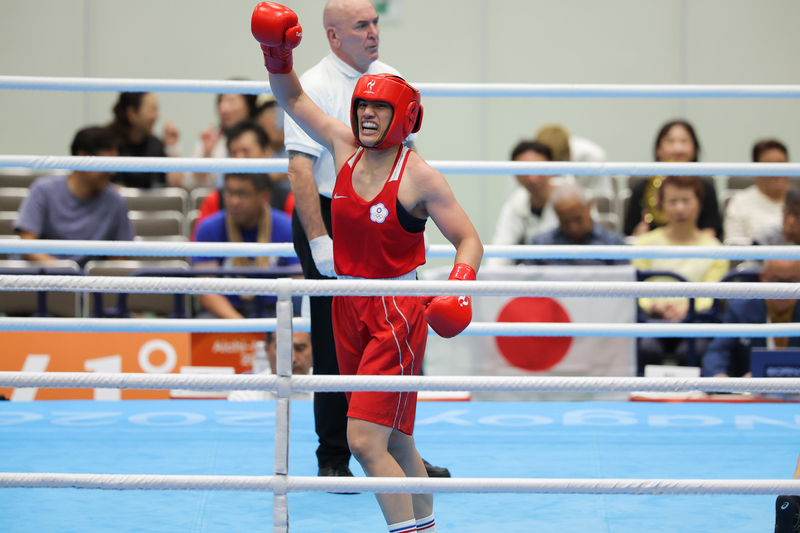 名古屋亞運29日女子拳擊65公斤級4強賽,台灣好手陳念琴(紅衣),舉起右手向現場粉絲致意。圖/中央社