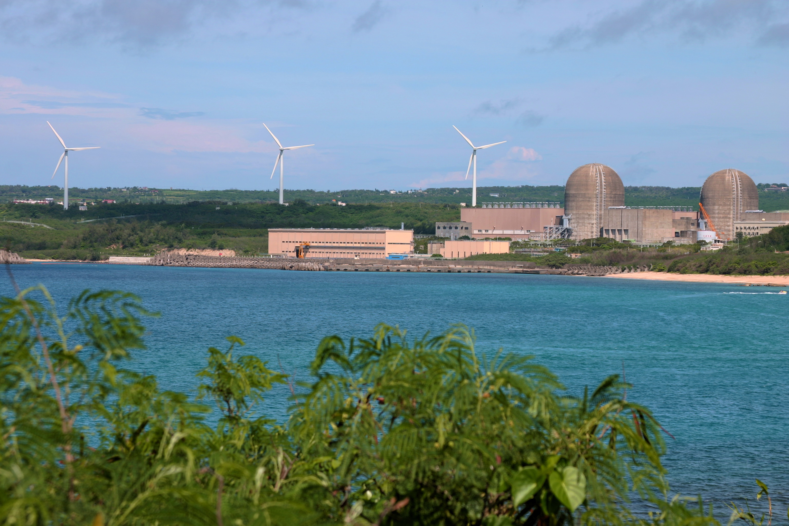 凱米颱風帶來強勁風勢，台電表示24日當天風機發電量相當於核三。圖為核三機組與風力發電。圖／核三廠提供
