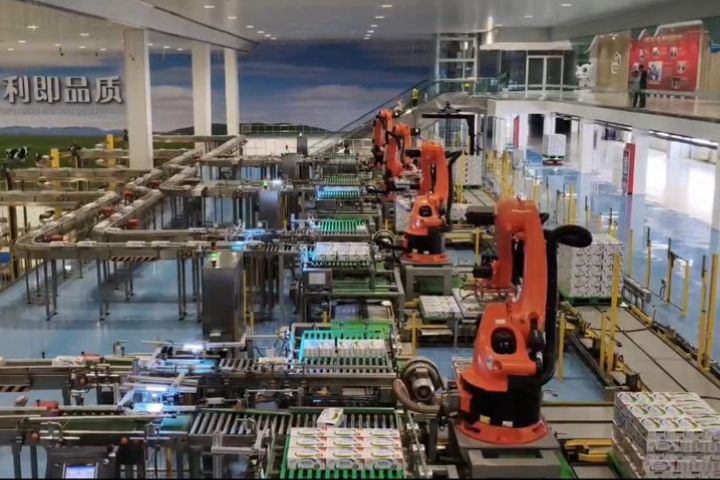 機械臂以真空吸附的方式吸起奶箱,一條機械手臂能負責的工作量,相當於60名人工。圖/記者陳素貞攝