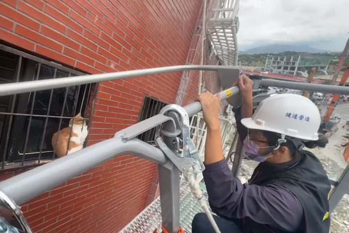 花蓮縣消防隊員準備對困在天王星大樓7樓鐵窗夾縫的貓展開救援。圖/取自花蓮縣消防局《臉書》粉專