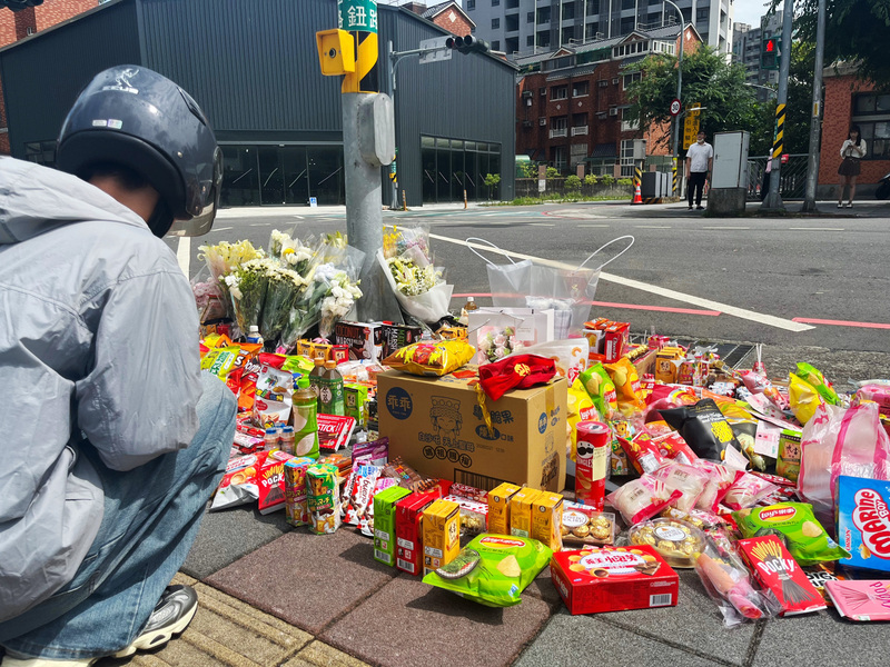 新北市三峽區北大國小外重大車禍造成3死、12傷，20日上午事故現場擺滿鮮花及零食，向逝者致意，願他們安息，並有民眾雙手合十為仍在醫院搶救的傷者祈禱，盼盡快康復。圖/中央社