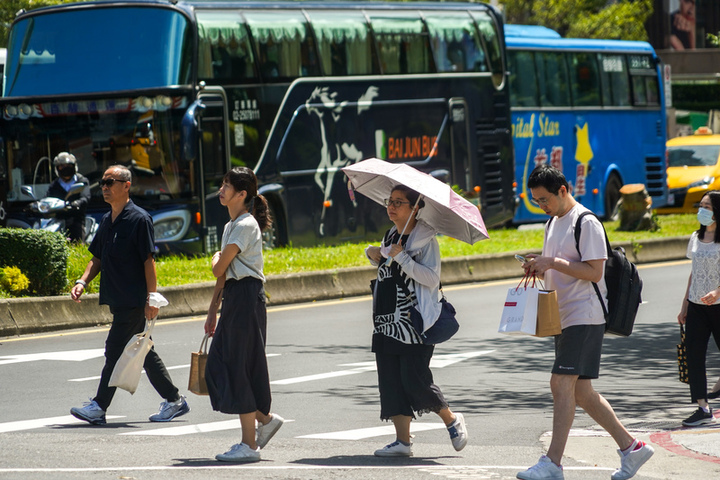 天氣炎熱，民眾外出撐傘遮陽。圖/取自中央社