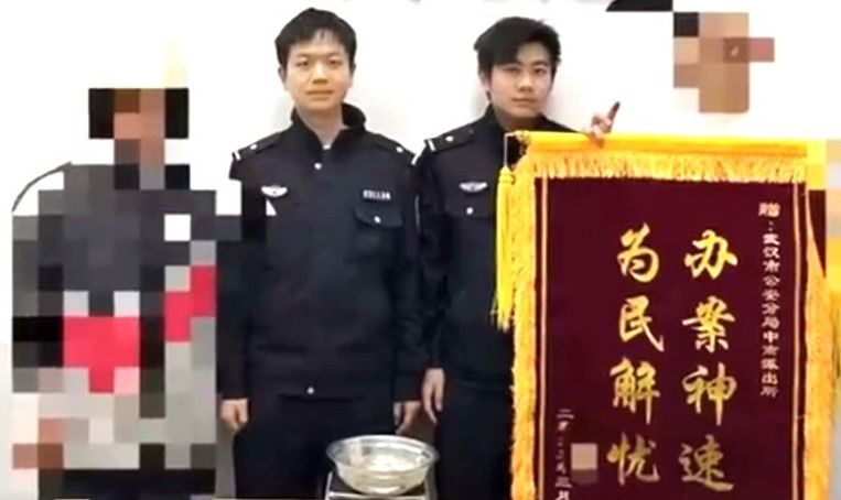 陳姓快遞員與章姓寄件人攜錦旗至派出所向警察致謝。圖/取自長江日報影片