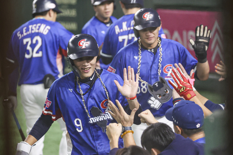 世界12強棒球賽複賽23日晚間在東京巨蛋由台灣與日本交手，台灣打者邱智呈6局敲安，隊友張政禹（前）、岳東華（後右）把握機會回本壘得分，在休息區後與隊友擊掌致意。圖／ 中央社