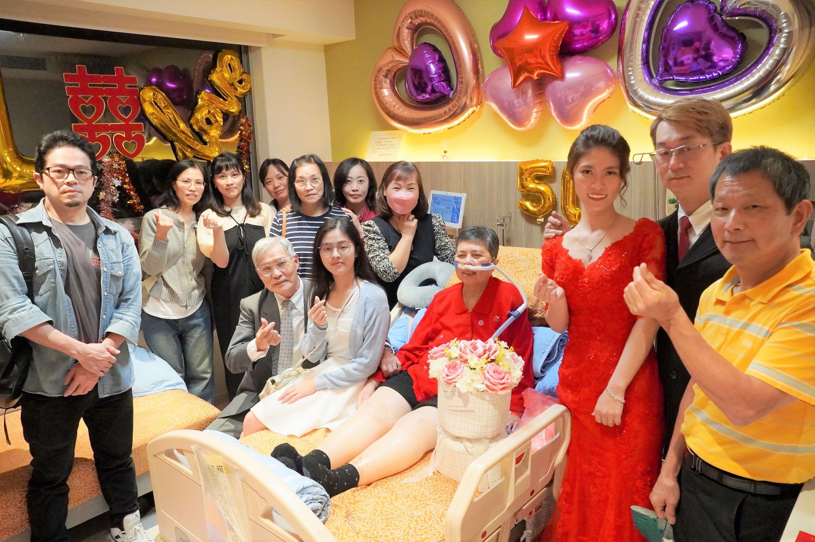 癌末患者廖女士（中間著紅衣）在病房中圓滿為女兒披上嫁衣的心願。圖/聯新國際醫院提供