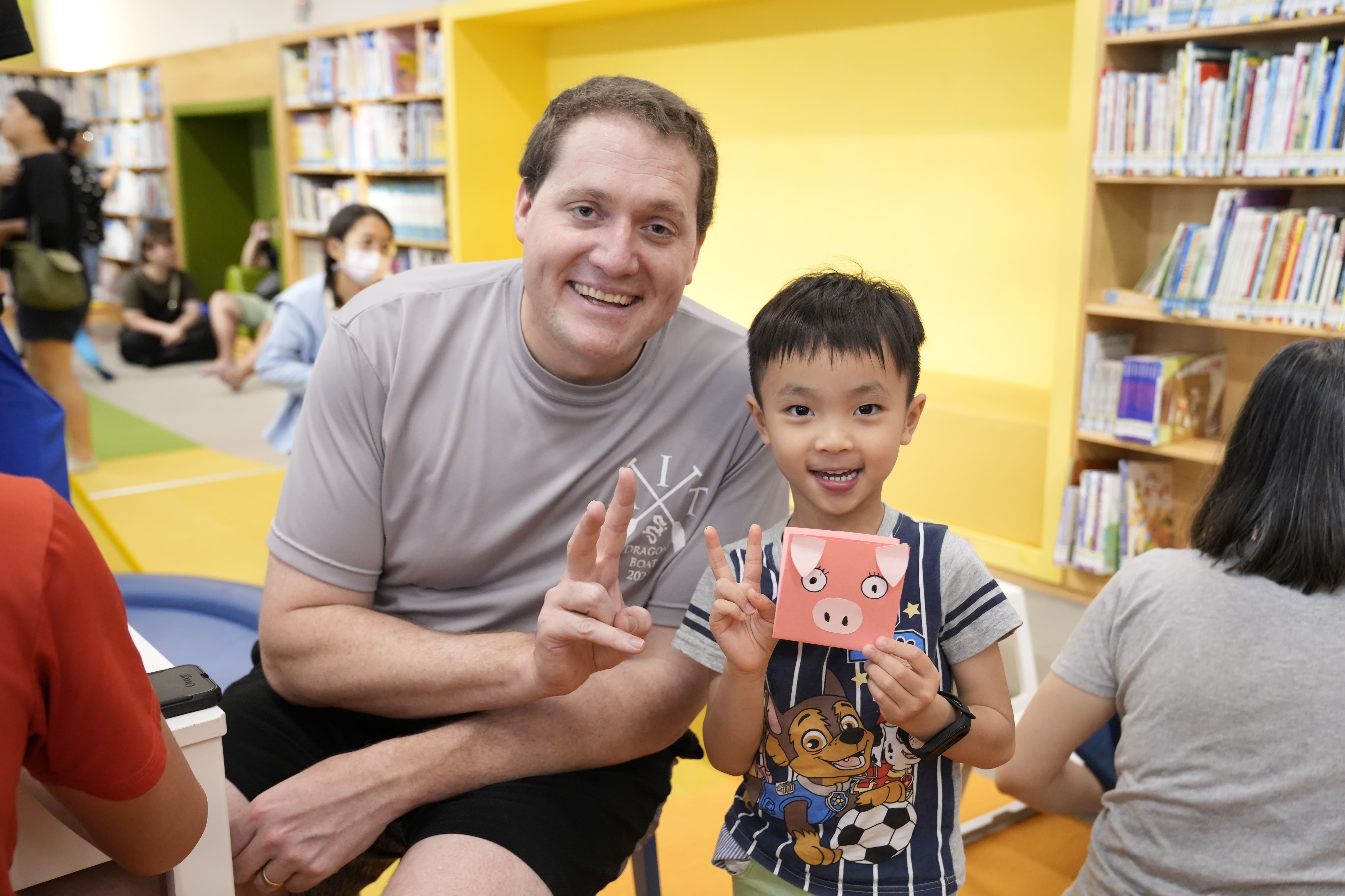 「故事聯合國」邀駐台代表說故事，AIT高雄分處長張子霖（Neil H. Gibson）與小朋友進行英文說故事活動與DIY「摺紙小豬」。圖/台文館提供