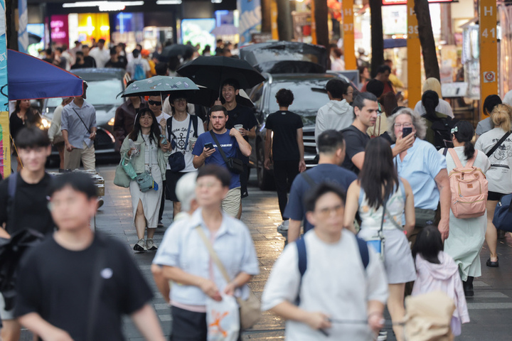 台北市雨勢趨緩，西門町出現逛街人潮。圖/取自中央社