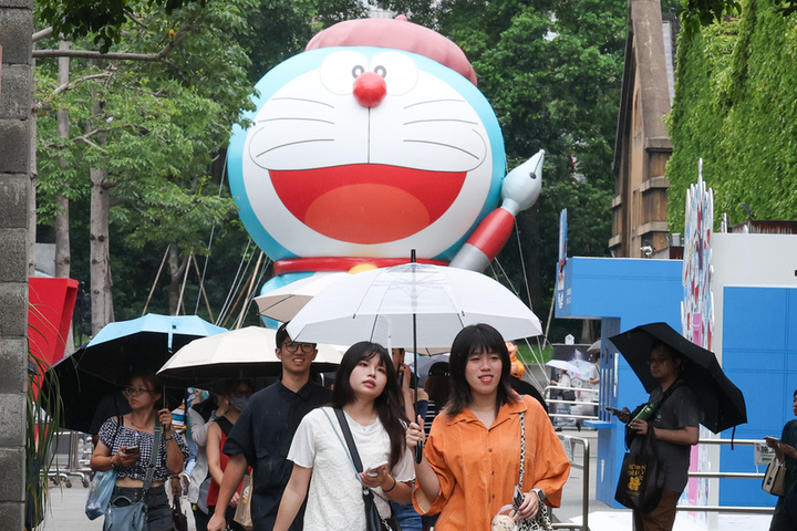 北市周日午後飄雨，民眾撐傘在華山文創園區內逛街。圖/取自中央社