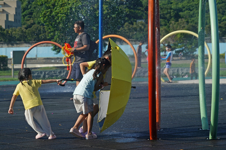 天氣高溫炎熱，兒童在公園戲水。圖/取自中央社