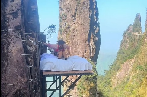 湖南郴州莽山五指峰景區建新設施，遊客可躺在1600公尺懸崖旁的床上。圖／取自微博